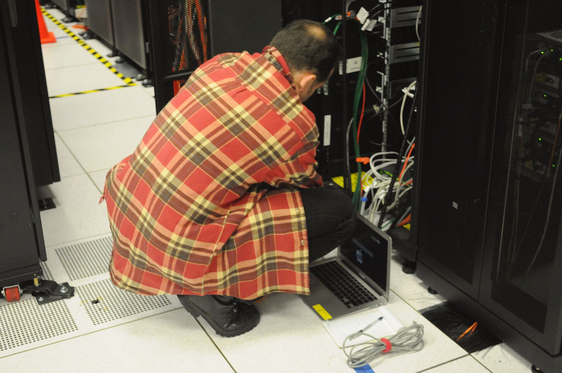 A technician working at a server rack